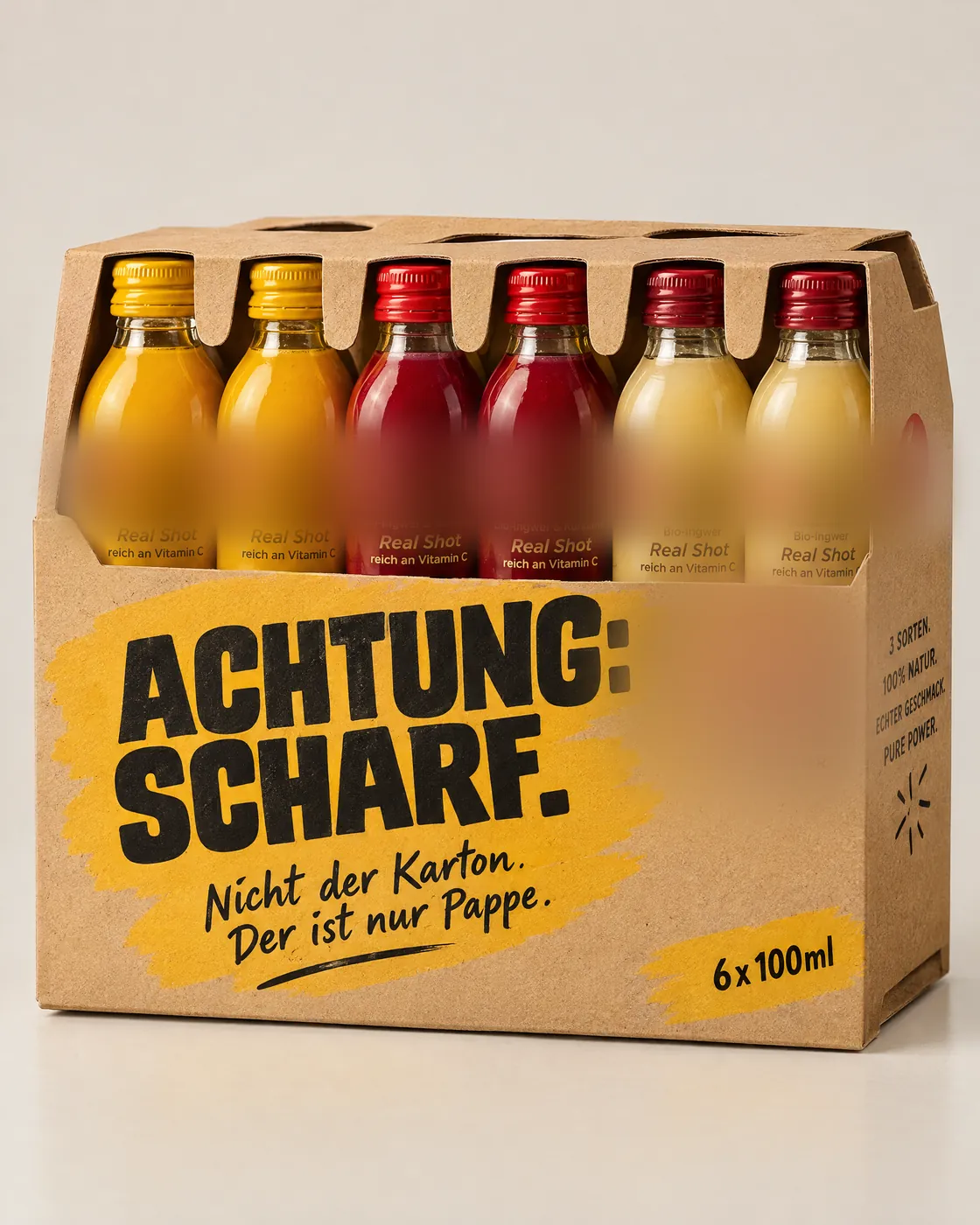 KI-Entwurf: 6er-Karton aus Kraftpapier, „Achtung: Scharf. Nicht der Karton. Der ist nur Pappe.“